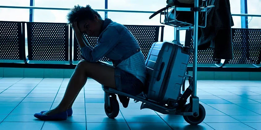 Mulher triste no aeroporto ap&oacute;s problema com voo Vueling