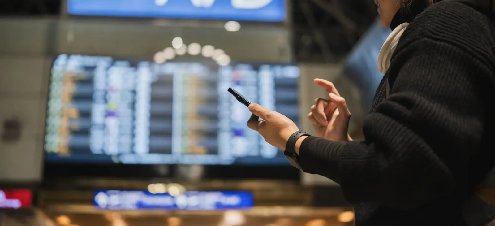 donna che controlla il telefono al terminal dell'aeroporto