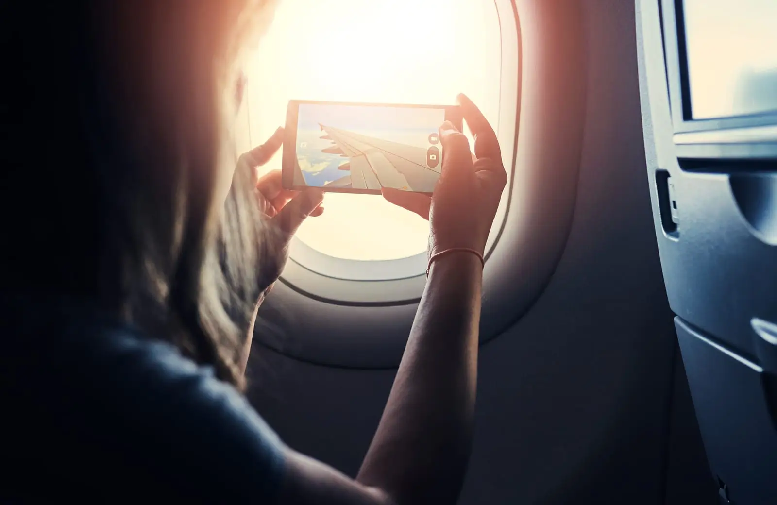 femme dans l'avion prenant une photo