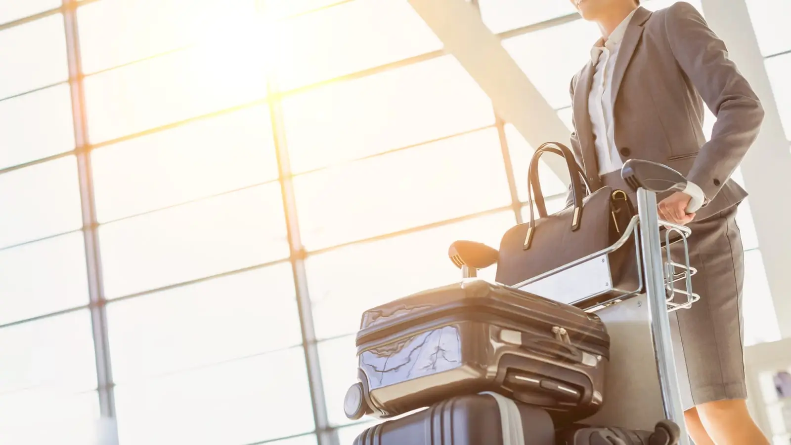 woman pushing baggage cart for check in at airport