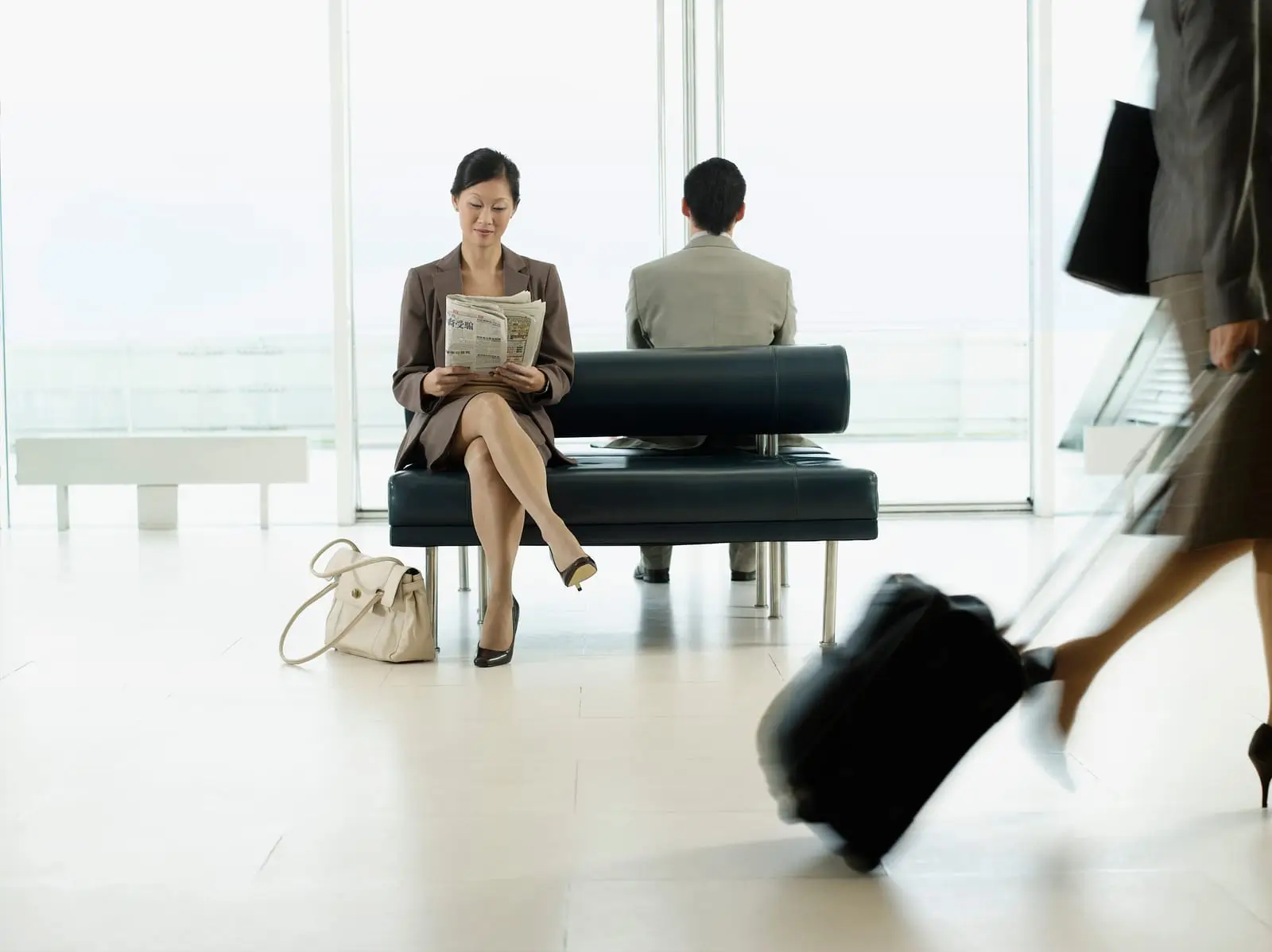 woman reading newspaper at airport lobby