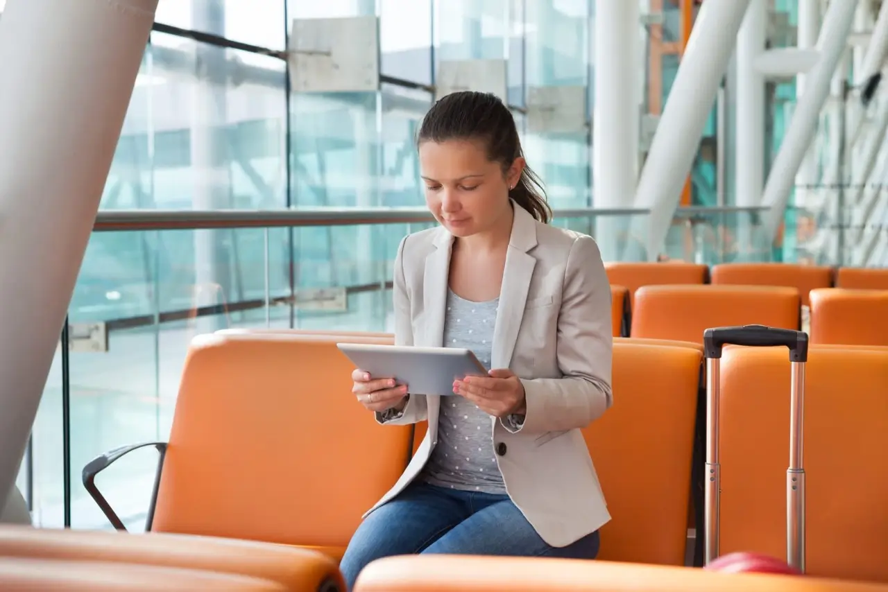 une femme avec une tablette dans un a&eacute;roport