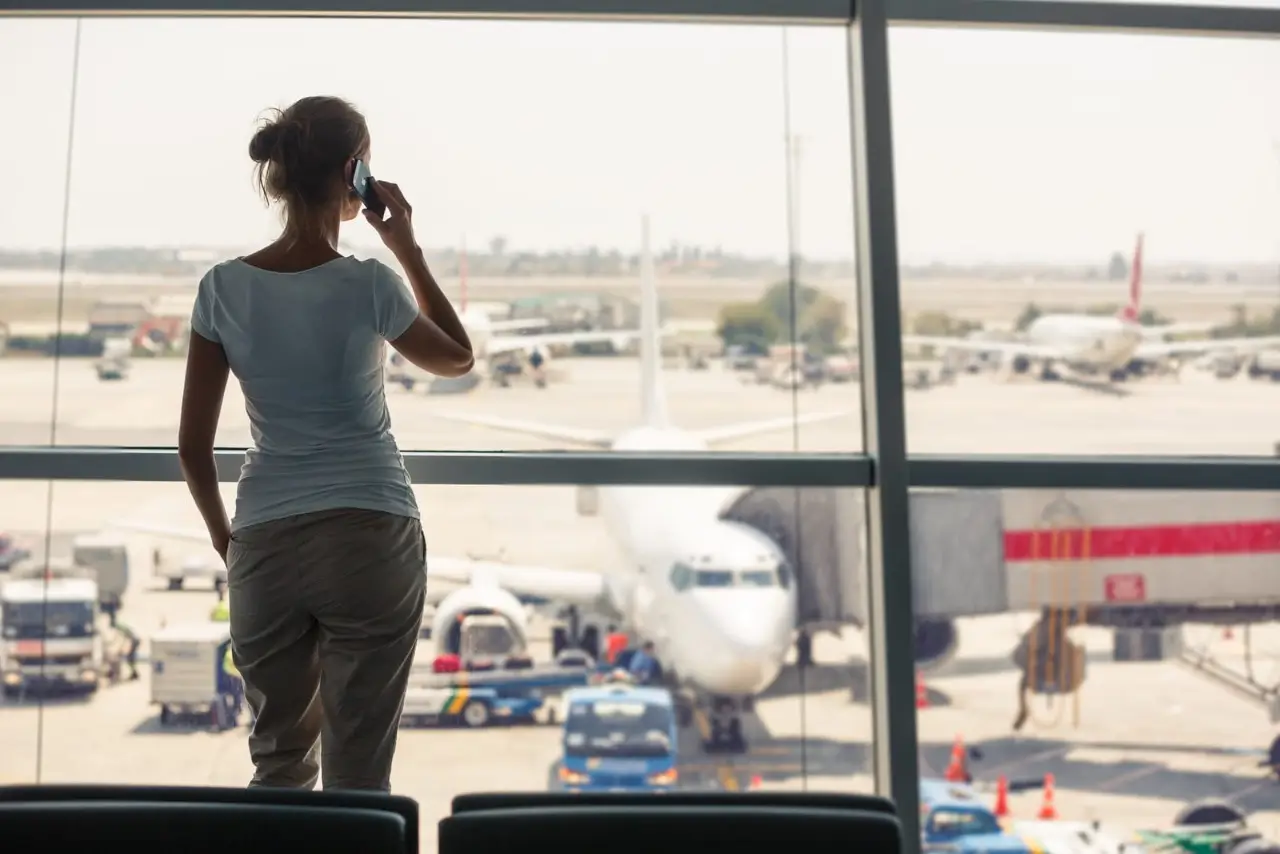 jeune femme attendant dans la zone d'embarquement d'un a&eacute;roport moderne
