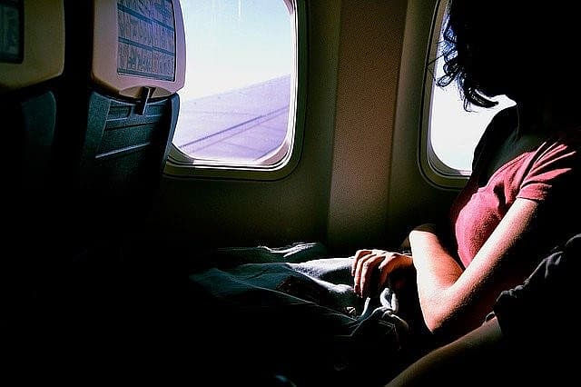 Frau blickt aus dem Flugzeugfenster
