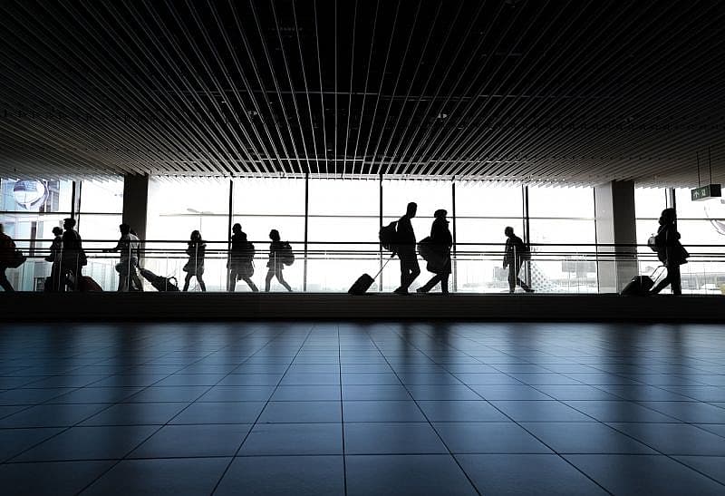 Sylwetki pasażer&oacute;w na lotnisku z bagażem podręcznym