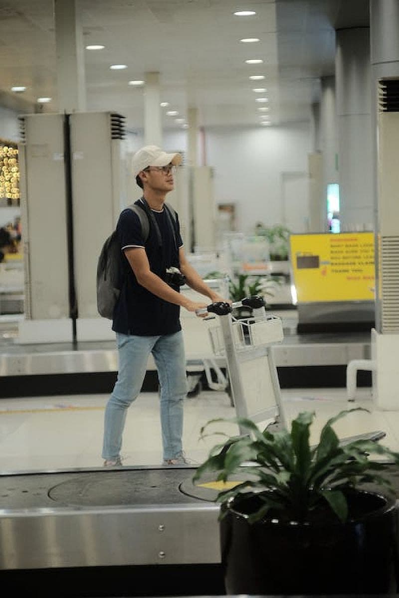 Ragazzo giovane con carrello in aeroporto