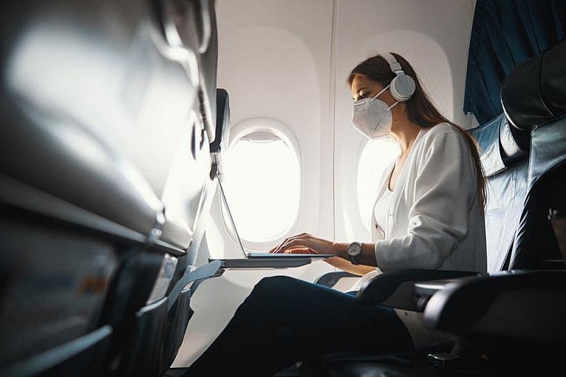 Mujer con su ordenador conectado al wifi en el avi&oacute;n