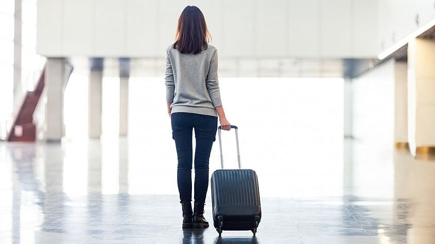 Donna con bagaglio che cammina in aeroporto