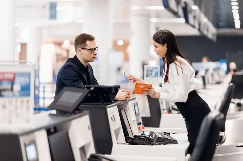Assistente della compagnia aerea che aiuta un passeggero 