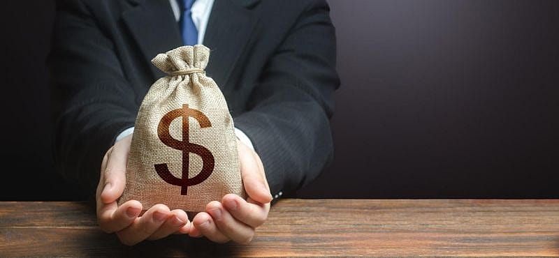 a businessman holding a bag of money