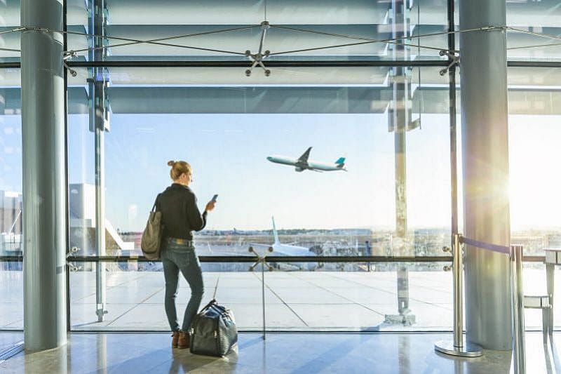 Passeggera in aeroporto davanti a una grande finestra