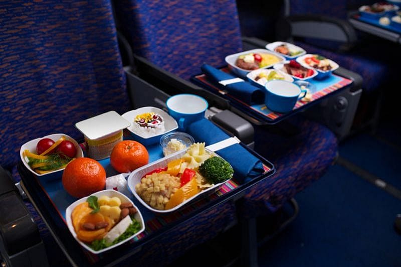 Due vassoi di cibo sui sedili dell&rsquo;aereo