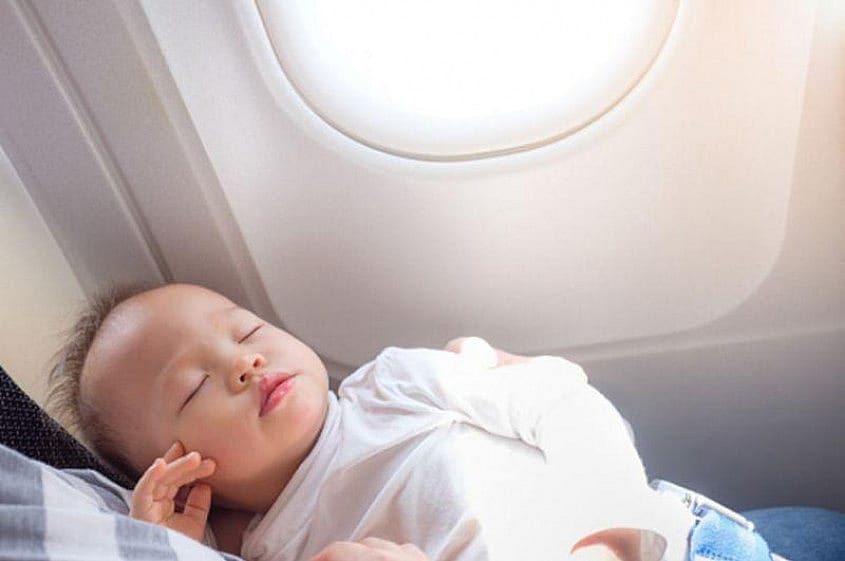 Ett sp&auml;dbarn som sover p&aring; ett flygplan
