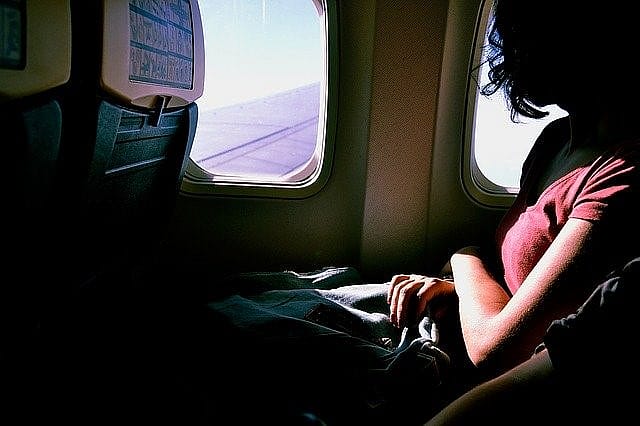 Frau blickt aus dem Flugzeugfenster