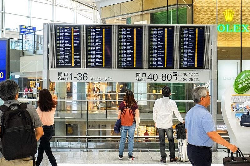 Menschen schauen auf Boardingzeiten am Flughafen