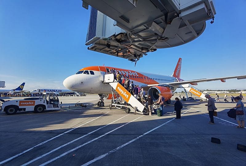 Mensen wacht op EasyJet vlucht op Schiphol - instappen vliegtuig