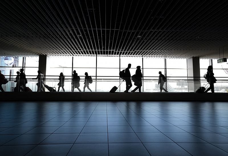 Sylwetki pasażer&oacute;w na lotnisku z bagażem podręcznym