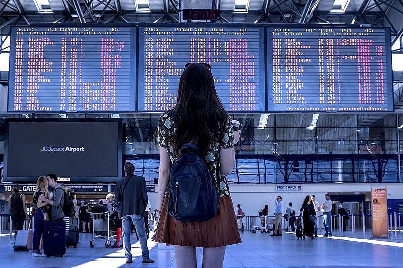 Ragazza che guarda tabelloni con gli orari degli aerei