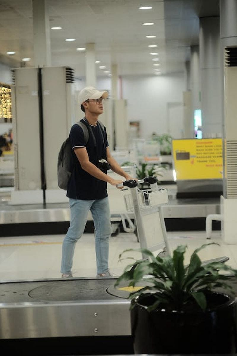 Ragazzo giovane con carrello in aeroporto