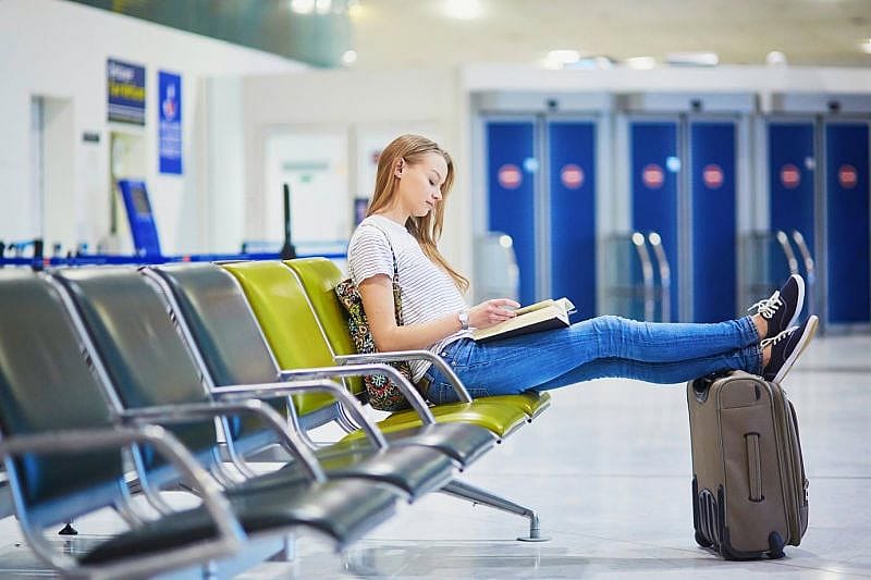 a woman reading a book while waiting for her delayed flight