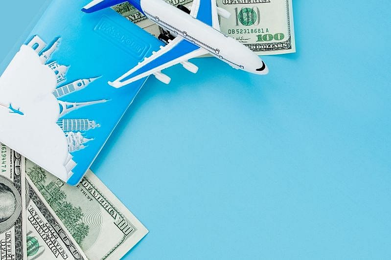 Reisepass mit Modell eines Passagierflugzeugs und Dollars auf blauer Fl&auml;che