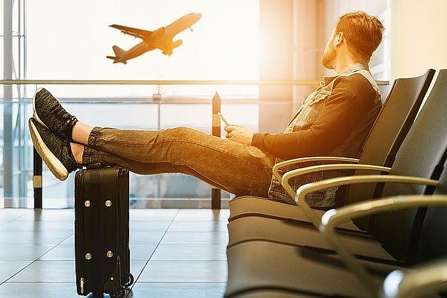 Un passager qui attend et regarde un avion qui d&eacute;colle