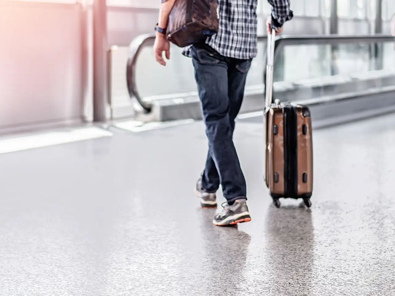 un hombre con una maleta camina por un aeropuerto