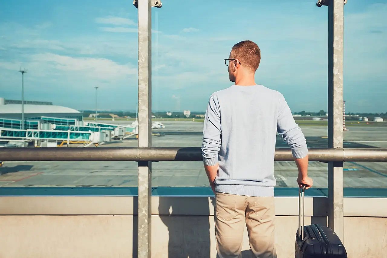 un pasajero con su maleta en un aeropuerto