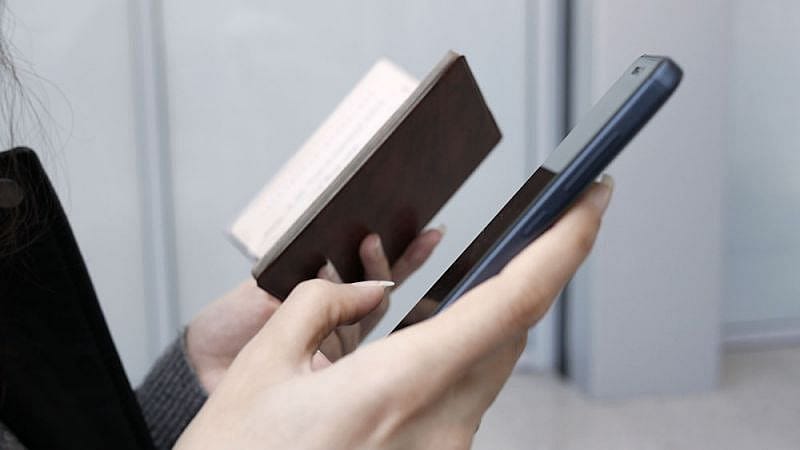 Mujer buscando informaci&oacute;n en su tel&eacute;fono m&oacute;vil sobre reclamaciones a Air Dolomiti