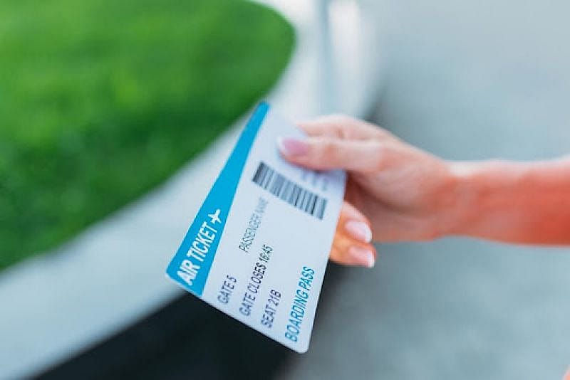 Mujer solicitando la devoluci&oacute;n de su billete de avi&oacute;n con el ticket en la mano