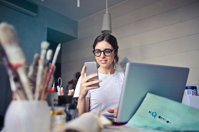 en tjej som kollar sin ers&auml;ttning i mobiltelefonen