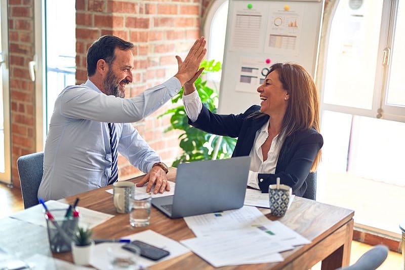 a man and a woman high five-ing after making a successful claim with AirAdvisor