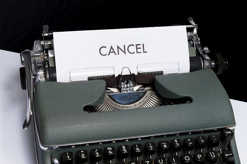 a typewriter with a page inside it that has the word cancel spelled on it