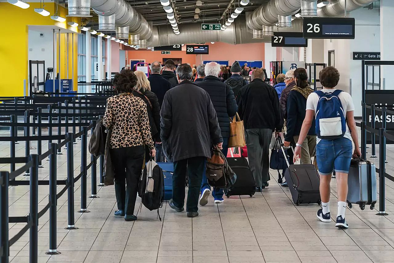 group of passengers walking to the gate before boarding the airplane