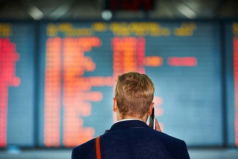 Pasajero afectado por retrasos de Delta Airlines habla por tel&eacute;fono en el aeropuerto 