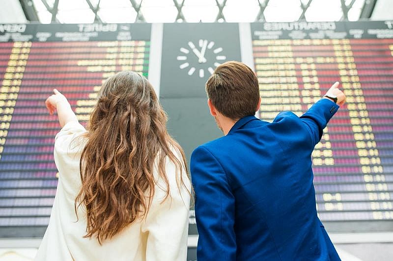Dos pasajeros viendo como British Airways cancela vuelos