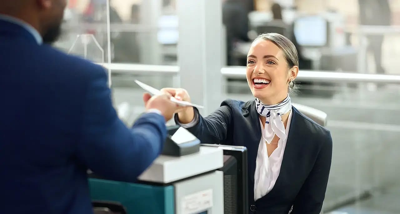 A friendly airline employee gives back the documents to the passenger