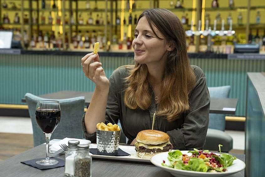 A traveller eating a meal in an airport restaurant during a flight delay