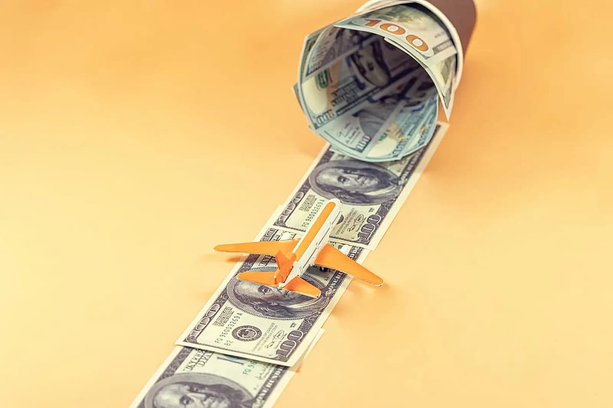 un avi&oacute;n y billetes en un vado naranja