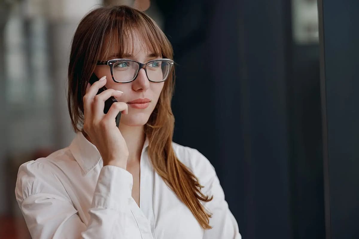 o femeie cu ochelari vorbește la telefon