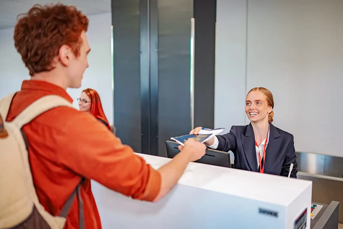 airport staff helping passenger at check in counter