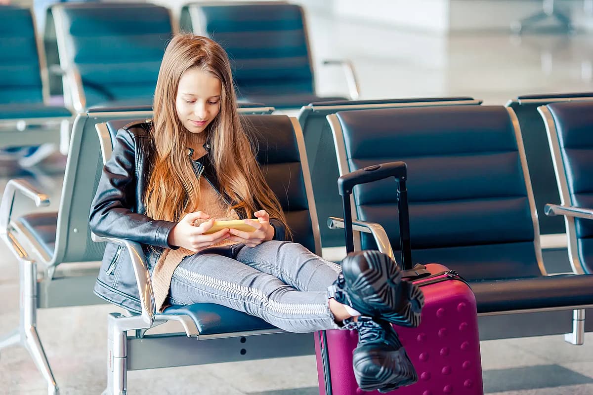 M&auml;dchen am Flughafen in einem gro&szlig;en internationalen Flughafen in der N&auml;he eines Fensters