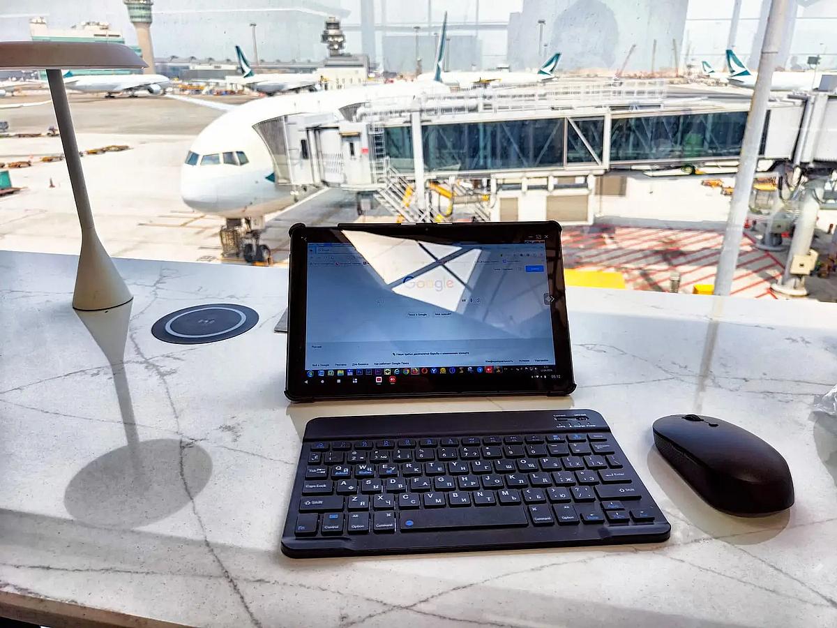 Reisender arbeitet mit einem Tablet am Flughafen