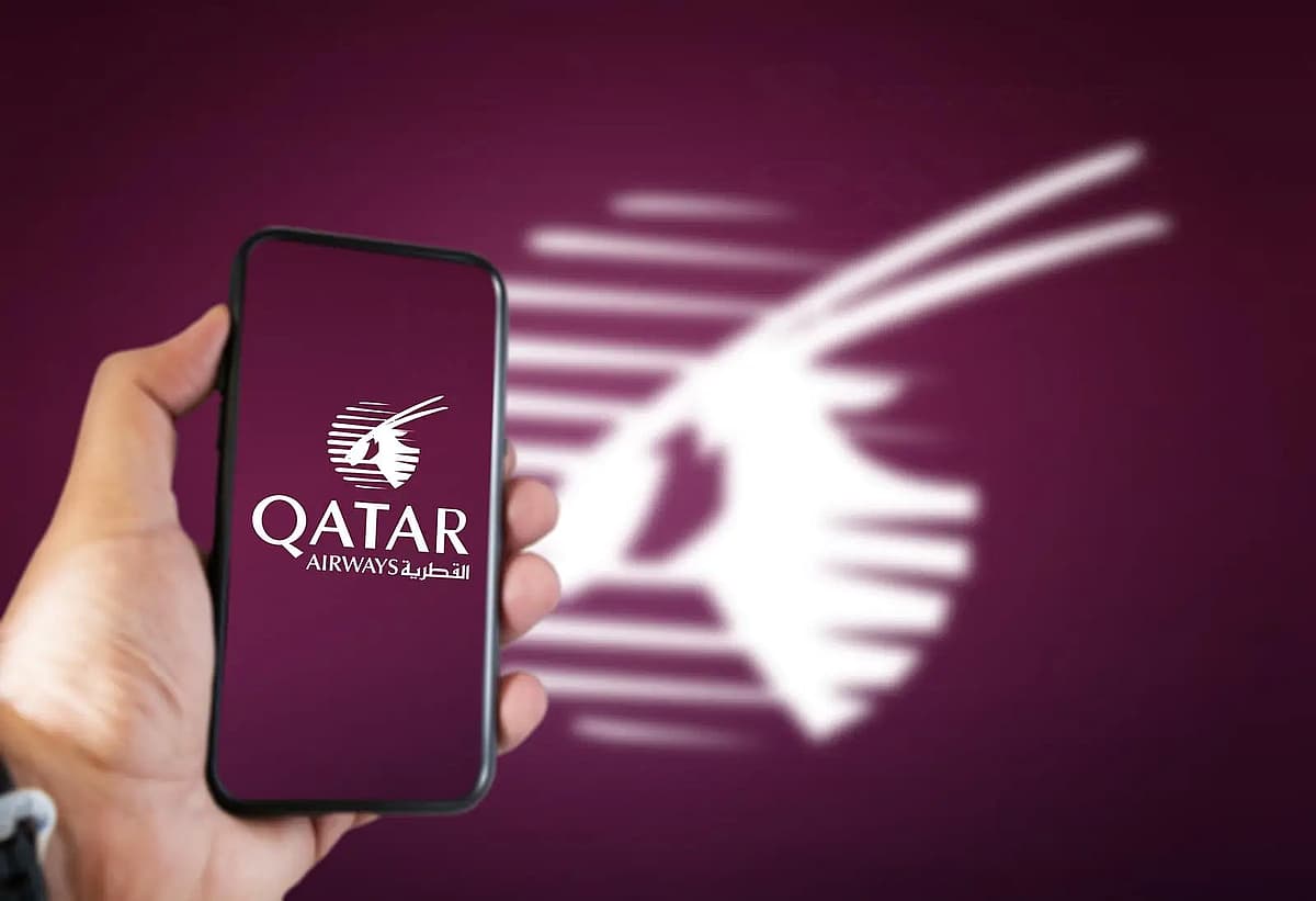 una mano che tiene un telefono con l'immagine di qatar airways