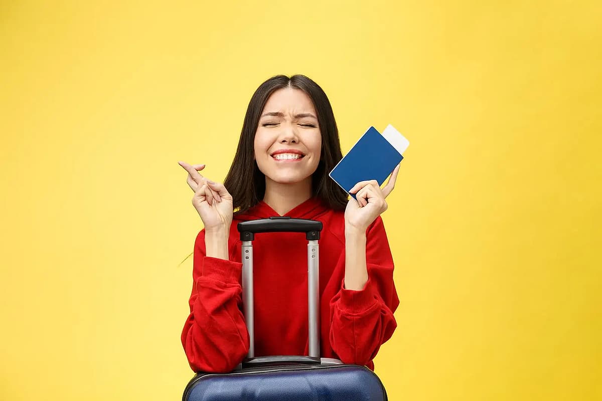 una mujer con su pasaporte y su maleta sobre fondo amarillo