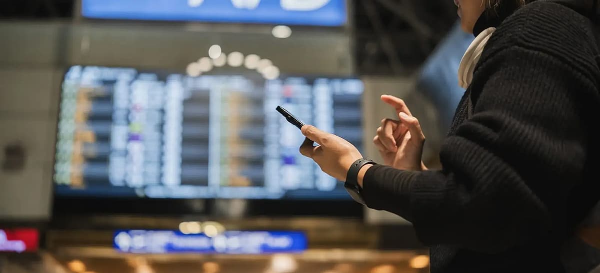 donna che controlla il telefono al terminal dell'aeroporto