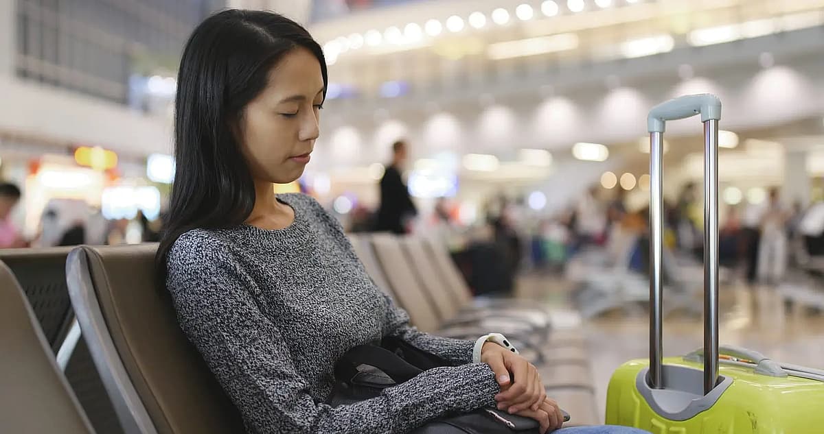 woman wait for check in and sleeping at airport with her luggage