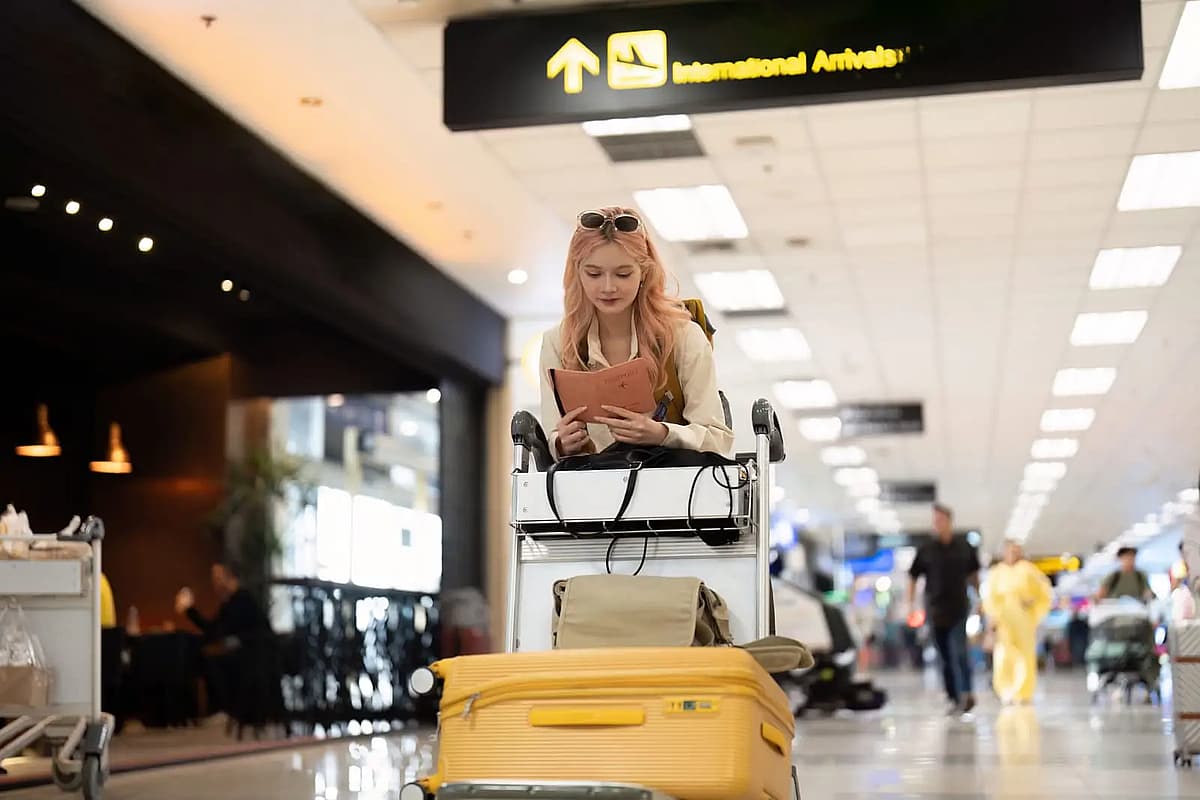 Joven mujer revisando su pasaporte en el aeropuerto