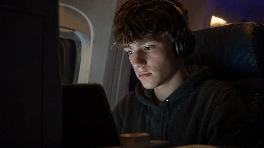 tinejdžer gleda film preko Wi-Fi-ja u avionu