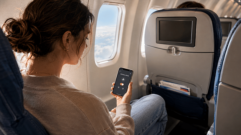 Putnik koristi telefon u avionu